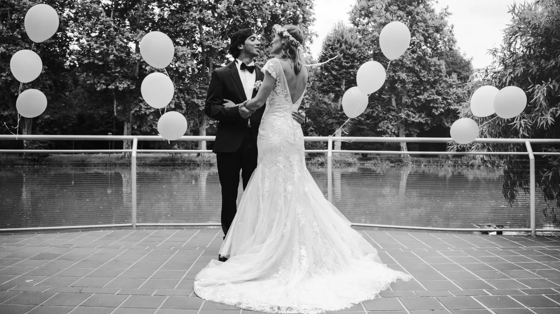 Hochzeitspaar das sich in die Augen schaut, umgeben von Luftballons